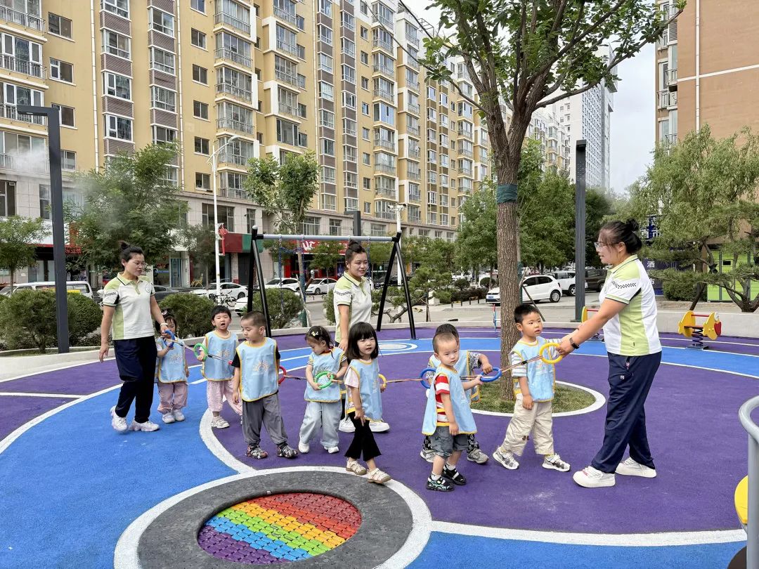 托育中心的老师们带着孩子们室外玩耍.jpg