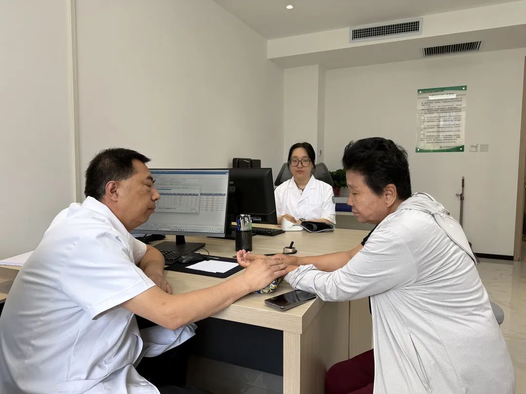 医生正在为老年人把脉，耐心地询问老人的身体情况.jpg