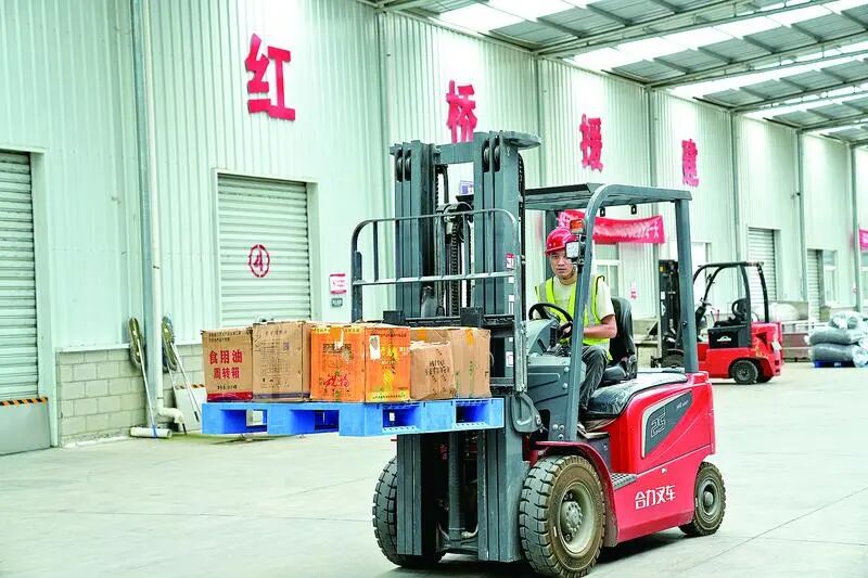 合水县津甘共建产业园内,工人搬运货物。 图片