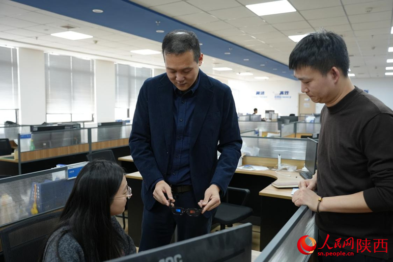 陈辰（中）正和研发团队讨论全彩Micro-LED光机的技术问题。人民网记者 李志强摄